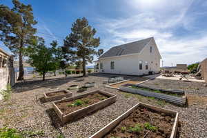 View of yard featuring fence, a patio, and a vegetable garden