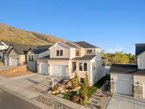 Traditional-style home featuring an attached garage, a mountain view, board and batten siding, and concrete driveway
