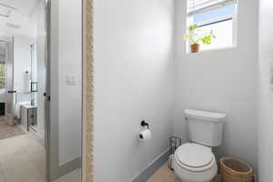 Bathroom with toilet, ensuite bathroom, and tile patterned flooring