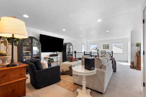 Carpeted living area with recessed lighting
