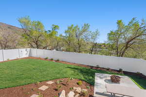 View of yard featuring a fenced backyard, a patio, and a fire pit