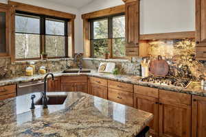 Kitchen featuring a sink, appliances with stainless steel finishes, lofted ceiling, and tasteful backsplash