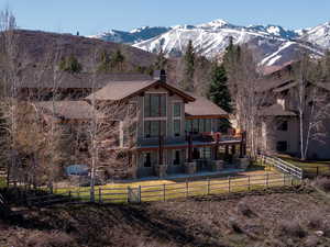 Rear view of house featuring a patio, a mountain view, a chimney, and a fenced backyard