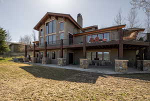 Back of property with a patio, central AC, a wooden deck, and a chimney