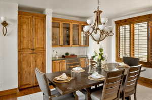 Dining space featuring baseboards, an inviting chandelier, and wood finished floors