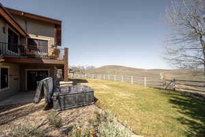 View of yard with a patio, a fenced backyard, a mountain view, and a balcony