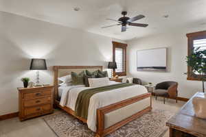 Bedroom featuring baseboards, ceiling fan, and light carpet