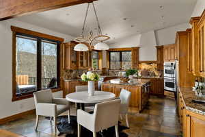 Dining room with baseboards, vaulted ceiling, recessed lighting, and stone finish flooring