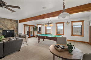 Game room with french doors, pool table, beam ceiling, baseboards, and light carpet