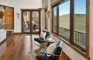 Doorway to outside featuring baseboards, plenty of natural light, french doors, and wood finished floors