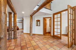 Interior space with light tile patterned floors, recessed lighting, french doors, and baseboards