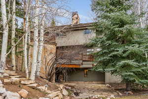 View of side of home featuring a balcony and a chimney