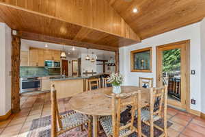 Dining room featuring wood ceiling, light tile patterned floors, baseboards, recessed lighting, and vaulted ceiling
