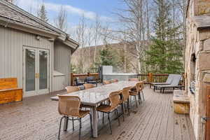 Wooden terrace with a mountain view, french doors, and outdoor dining space