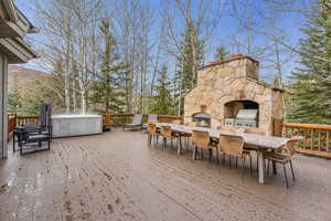 Wooden terrace featuring area for grilling and outdoor dining space