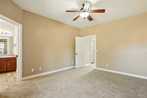 Unfurnished bedroom featuring baseboards, light colored carpet, and a sink
