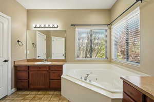 Bathroom with a tub with jets and vanity
