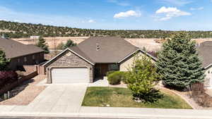 Ranch-style home featuring fence, an attached garage, stone siding, a front yard, and concrete driveway