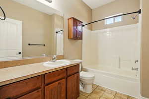 Bathroom with toilet, shower / bathing tub combination, and vanity