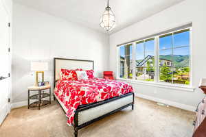 Carpeted bedroom with baseboards and visible vents