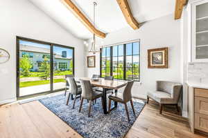 Dining space with light wood-type flooring, baseboards, a chandelier, and beamed ceiling