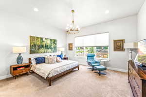 Carpeted bedroom featuring baseboards, recessed lighting, and a notable chandelier