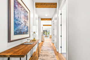 Hallway with recessed lighting, beam ceiling, and light wood-style floors