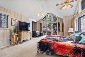 Bedroom featuring a wood stove, lofted ceiling, wooden walls, a chandelier, and carpet
