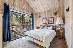 Carpeted bedroom with access to outside, wood ceiling, lofted ceiling, and wooden walls