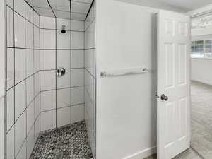 Bathroom featuring baseboards and tiled shower