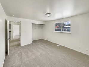Unfurnished bedroom with baseboards, carpet, a closet, and visible vents