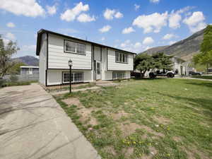 Split foyer home featuring fence, a mountain view, and a front yard