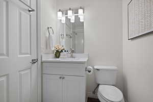 Full bath with toilet, walk in shower, and vanity