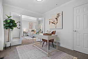 Office space with baseboards, visible vents, ornamental molding, and carpet
