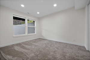 Carpeted empty room with visible vents, recessed lighting, and baseboards