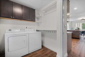Laundry room featuring recessed lighting, cabinet space, washer and clothes dryer, baseboards, and wood finish floors