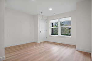 Spare room with baseboards, visible vents, light wood-style flooring, and recessed lighting