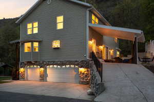 Traditional home featuring stone siding, concrete driveway, and a garage