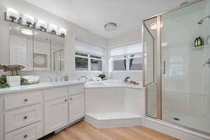 Master Bathroom featuring a stall shower, a bath, wood finished floors, and vanity