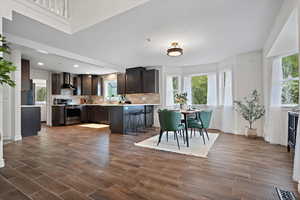 Kitchen featuring stainless steel electric range oven, a healthy amount of sunlight, light countertops, and wall chimney exhaust hood