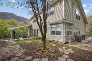 View of home's exterior featuring a patio area, central air condition unit, and a mountain view