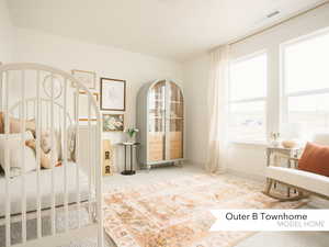 Carpeted bedroom featuring baseboards and visible vents