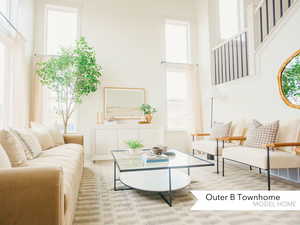Living area featuring baseboards and a towering ceiling