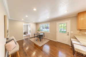 Dining room featuring recessed lighting, dark wood finished floors, crown molding, and baseboards