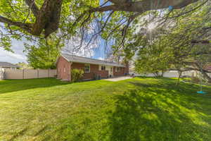 View of yard with fence, a patio area, and central AC