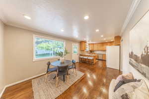 Dining area with recessed lighting, baseboards, ornamental molding, and wood finished floors