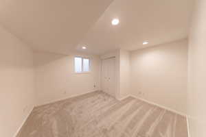 Below grade area with light carpet, recessed lighting, and baseboards