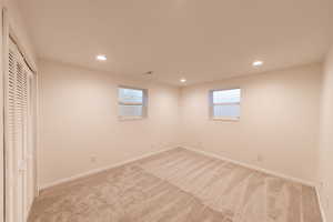 Unfurnished bedroom featuring light colored carpet, recessed lighting, baseboards, and a closet