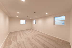 Basement featuring recessed lighting, light colored carpet, and baseboards