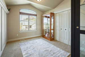 Unfurnished bedroom with visible vents, baseboards, a closet, lofted ceiling, and carpet flooring